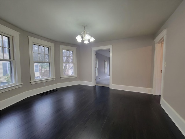 unfurnished dining area with dark wood-style floors, visible vents, a notable chandelier, and baseboards