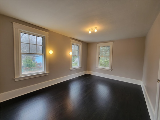 unfurnished room featuring dark wood-style floors and baseboards