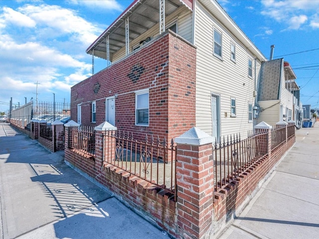 view of side of home with brick siding and a fenced front yard