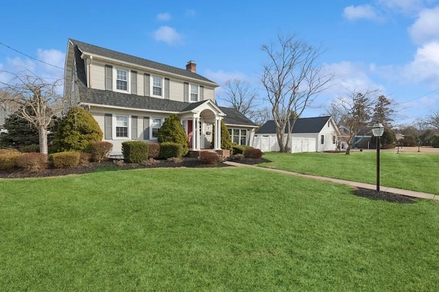 colonial inspired home featuring a chimney and a front lawn