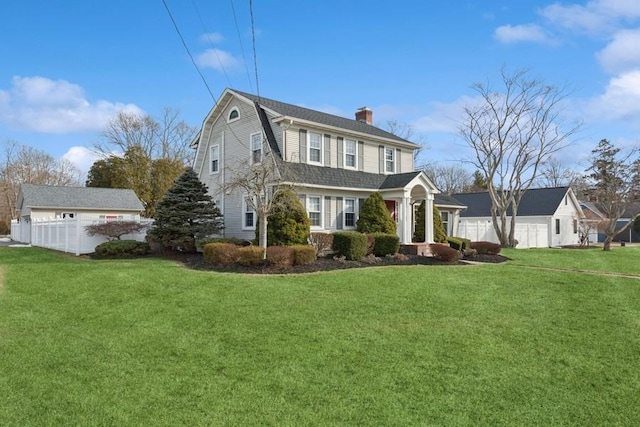 view of front of house with a front yard, a chimney, fence, and a gambrel roof