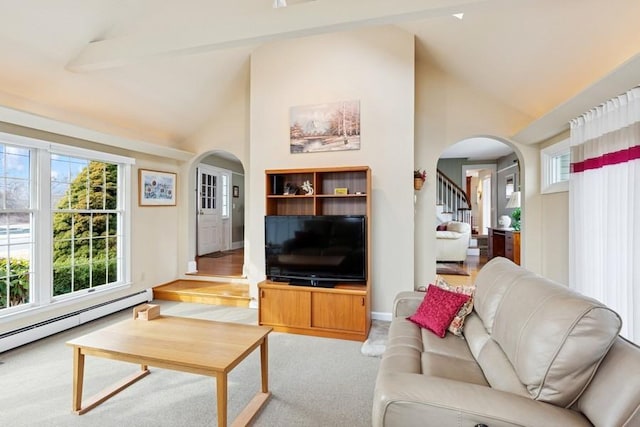 living area featuring a baseboard heating unit, arched walkways, and plenty of natural light