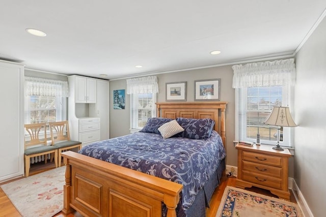 bedroom featuring light wood-style flooring, multiple windows, baseboards, and crown molding