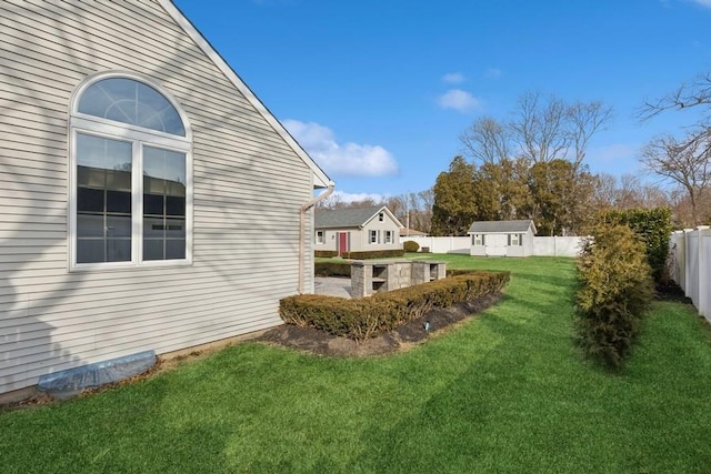 view of yard featuring an outbuilding, a shed, and a fenced backyard