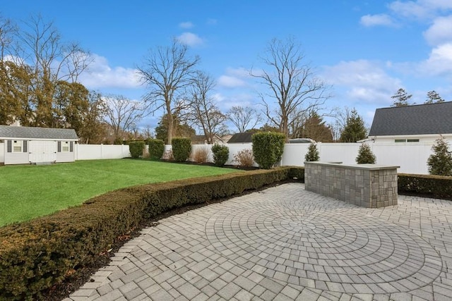 view of patio with an outbuilding and a fenced backyard