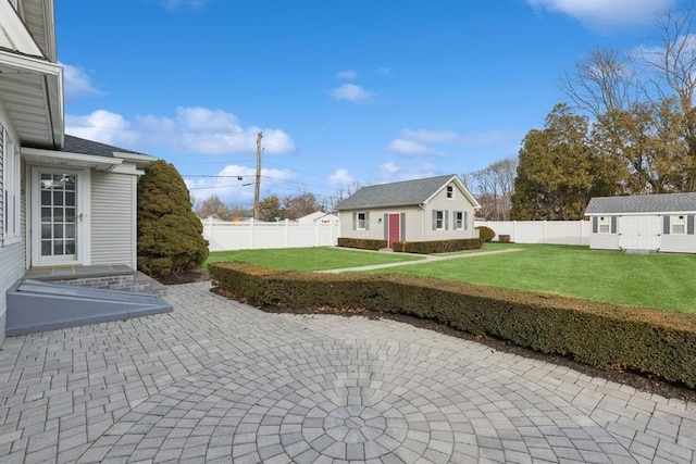 view of yard with a patio area, an outdoor structure, and a fenced backyard