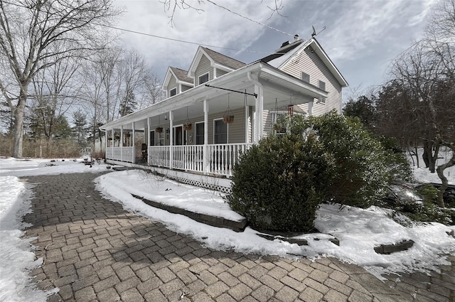 view of snowy exterior with a porch