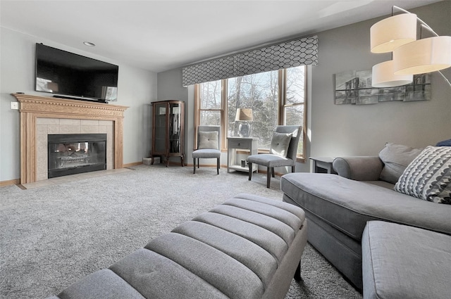 carpeted living area with baseboards and a tile fireplace