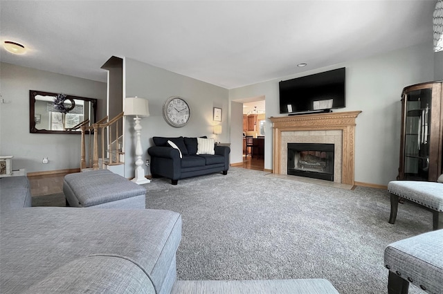 living area featuring stairway, a fireplace, and baseboards