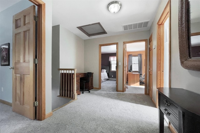 hallway featuring carpet, visible vents, and baseboards