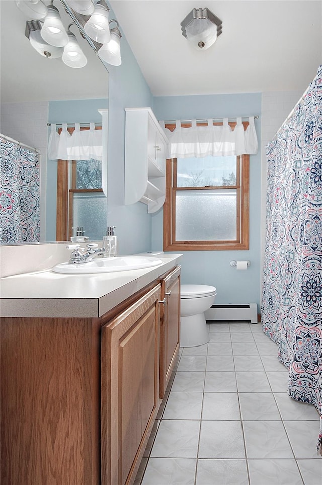 bathroom featuring a baseboard heating unit, toilet, tile patterned flooring, and vanity