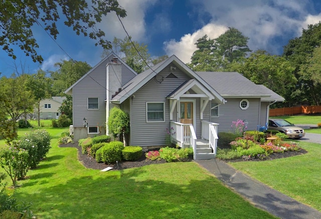 bungalow-style home with a front lawn and fence