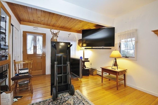 entryway featuring baseboard heating, a healthy amount of sunlight, wooden ceiling, and wood finished floors