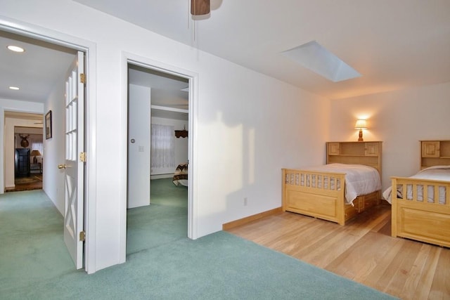 bedroom with ceiling fan, baseboards, carpet floors, recessed lighting, and a skylight