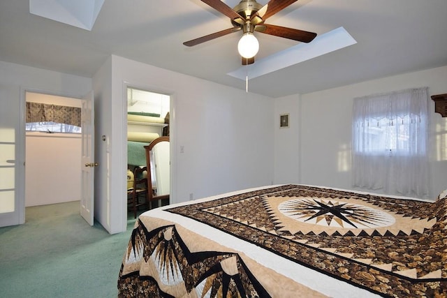 bedroom with a skylight, a ceiling fan, and carpet floors