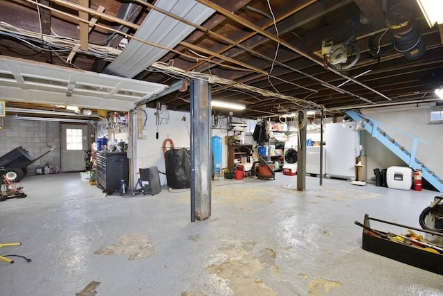 basement featuring washer / dryer, water heater, and freestanding refrigerator