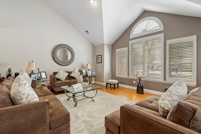 living area featuring a healthy amount of sunlight, light wood finished floors, baseboards, and visible vents