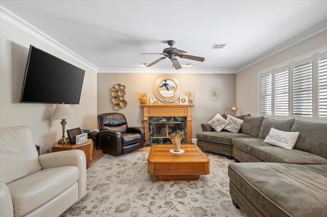 living room featuring a high end fireplace, visible vents, a ceiling fan, and ornamental molding