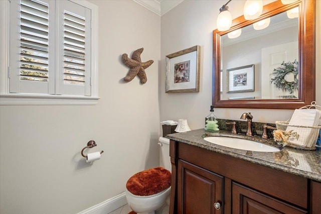 bathroom with ornamental molding, toilet, vanity, and baseboards