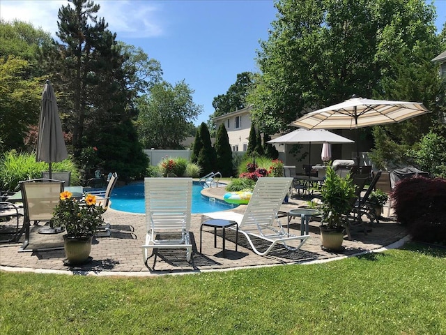 pool featuring fence, a patio, and a yard