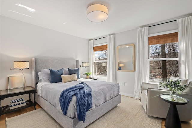 bedroom with baseboards and wood finished floors