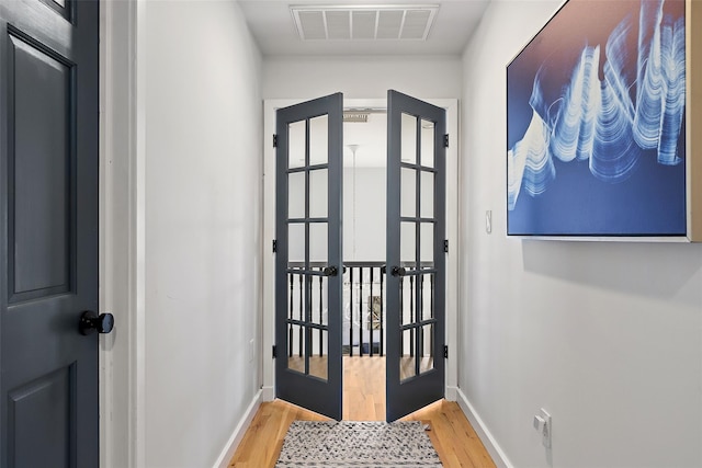 doorway to outside featuring visible vents, french doors, baseboards, and light wood-style floors