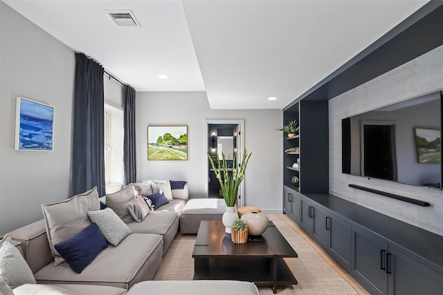 living room with recessed lighting, visible vents, and light wood-type flooring