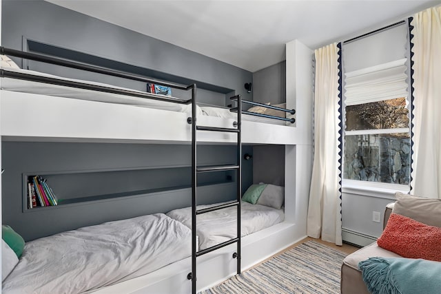 bedroom featuring wood finished floors and a baseboard radiator