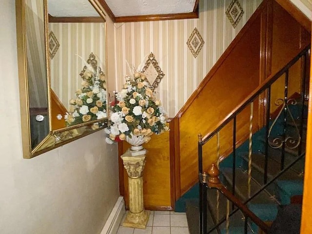 interior space featuring a baseboard heating unit, light tile patterned floors, ornamental molding, and wallpapered walls