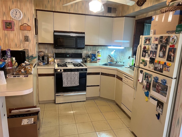 kitchen featuring white appliances, light countertops, a sink, and visible vents