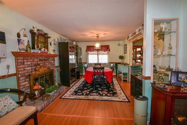 dining space featuring a fireplace and wood finished floors