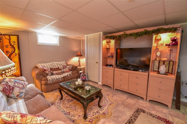 living room with a paneled ceiling and light tile patterned floors