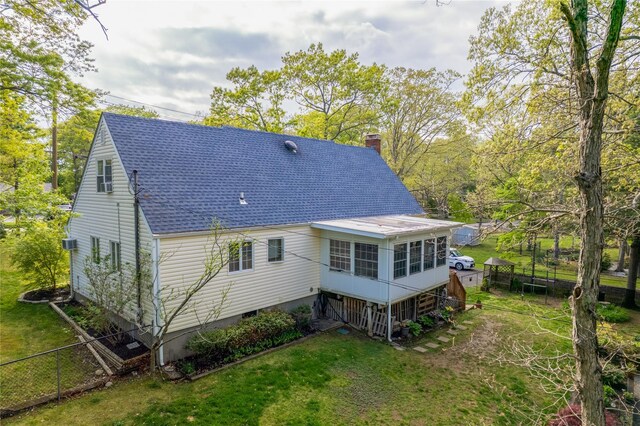 337 Mount Sinai Coram Rd, Mount Sinai, NY 11766 - rear view of house featuring a chimney, a shingled roof, a sunroom, and a lawn