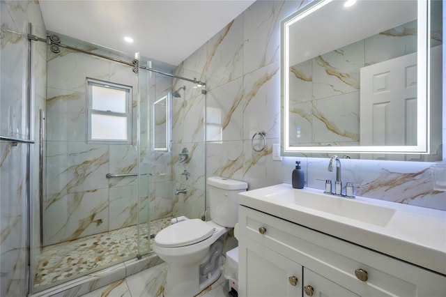 bathroom featuring a marble finish shower, toilet, marble finish floor, vanity, and tile walls