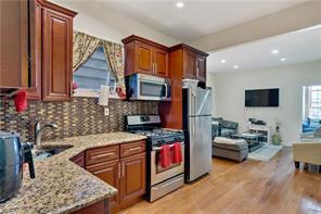 kitchen with light wood finished floors, tasteful backsplash, appliances with stainless steel finishes, open floor plan, and a sink