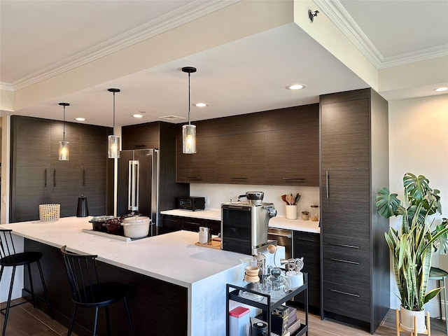 kitchen featuring modern cabinets, a breakfast bar area, light countertops, and high end fridge