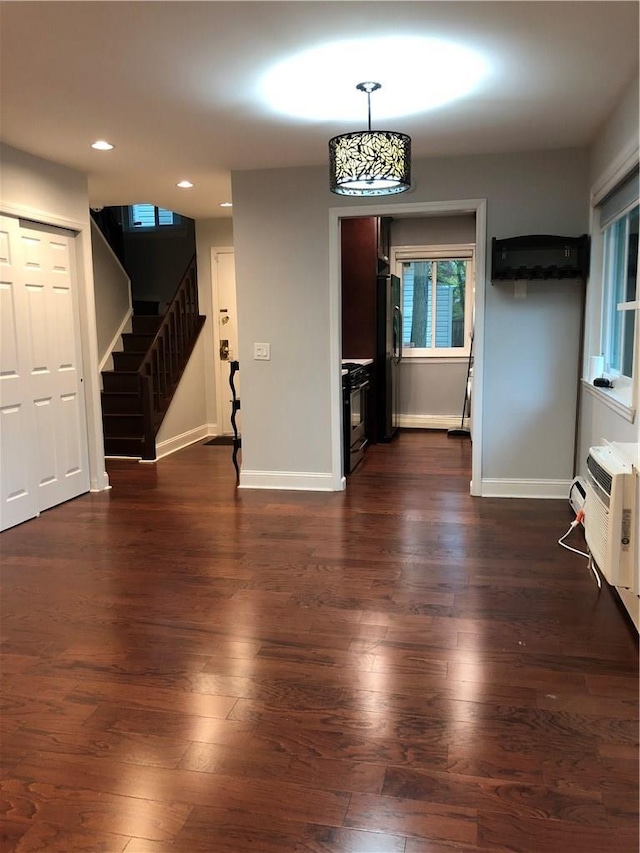 interior space with recessed lighting, baseboards, stairs, dark wood-style floors, and a wall mounted air conditioner