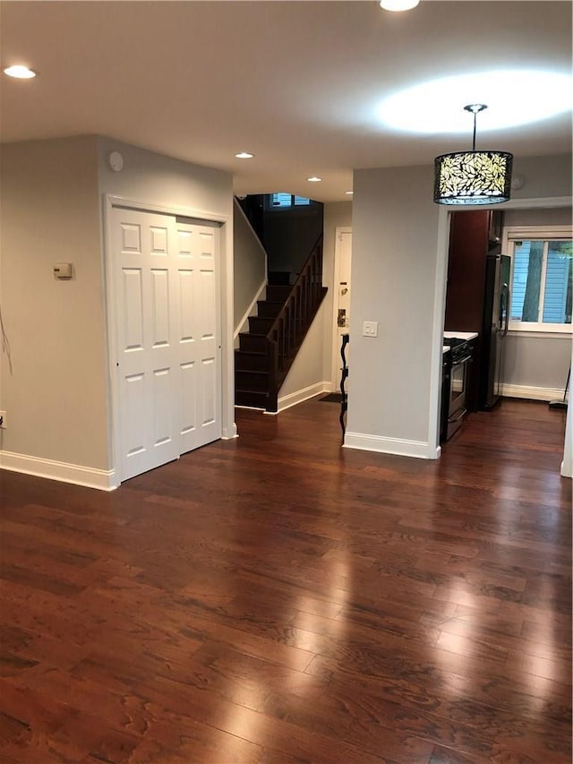 interior space featuring baseboards, stairway, dark wood-type flooring, and recessed lighting