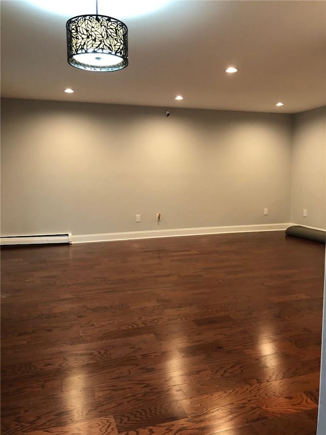 empty room featuring a baseboard radiator, baseboards, dark wood-style flooring, and recessed lighting