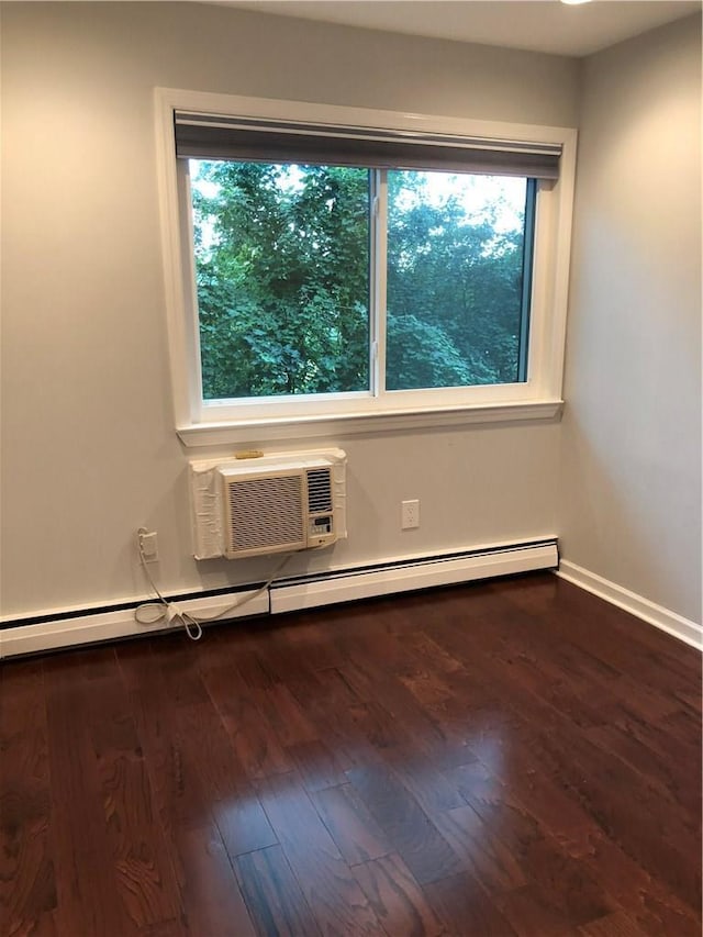 unfurnished room featuring baseboards, baseboard heating, dark wood-type flooring, and an AC wall unit