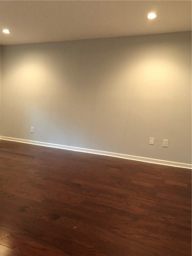 unfurnished room featuring recessed lighting, dark wood finished floors, and baseboards