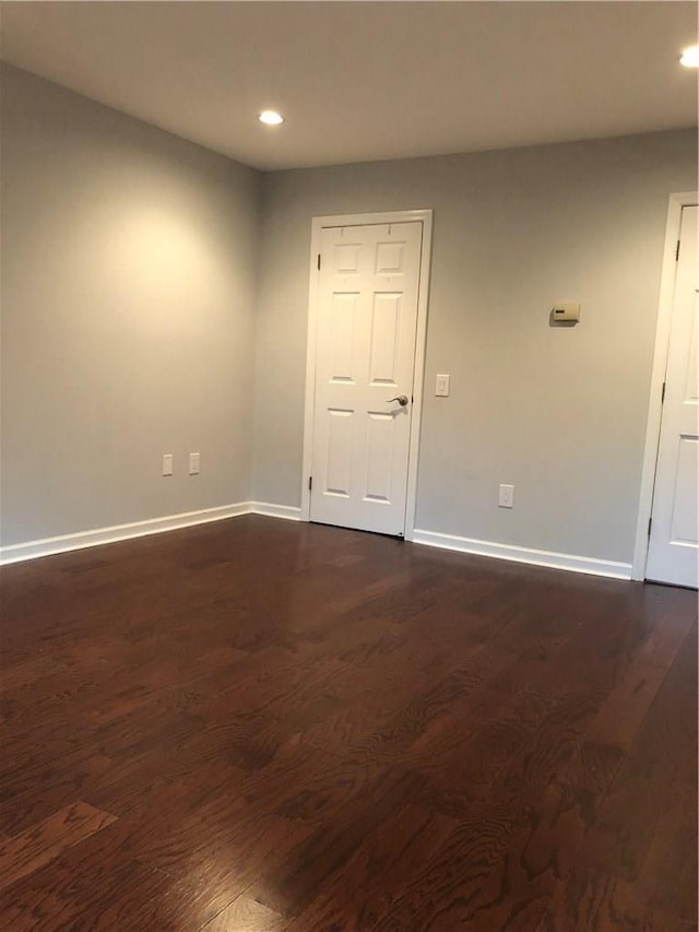 unfurnished room with dark wood-style floors, recessed lighting, and baseboards