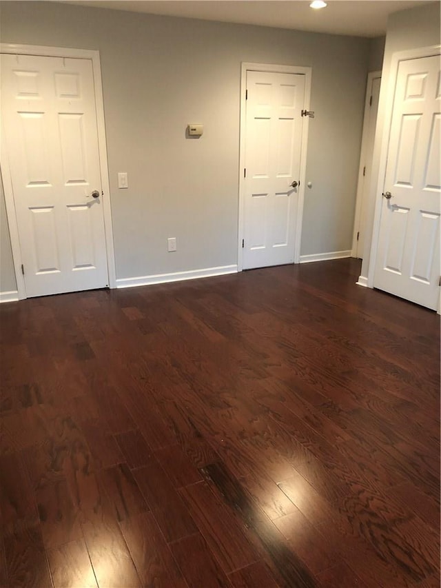 empty room featuring dark wood-type flooring and baseboards