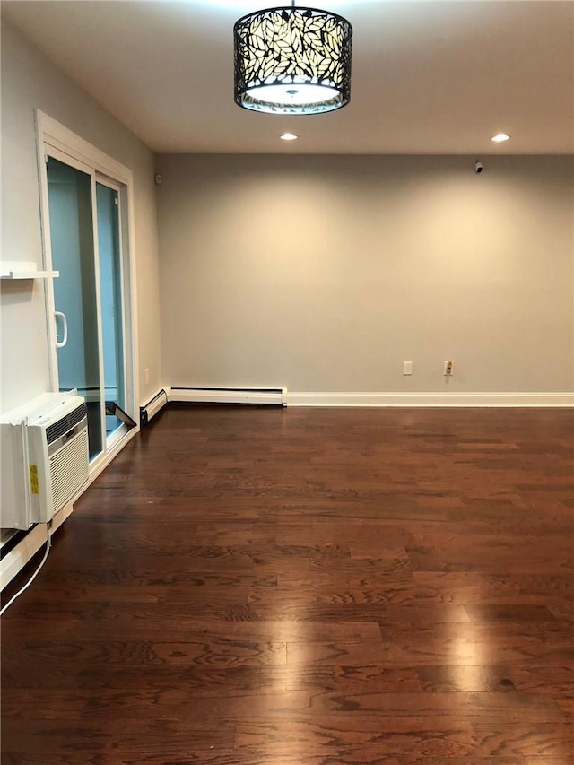 unfurnished room with a wall unit AC, recessed lighting, a baseboard heating unit, dark wood-type flooring, and baseboards