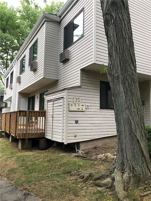 view of side of home featuring a deck and a wall mounted AC