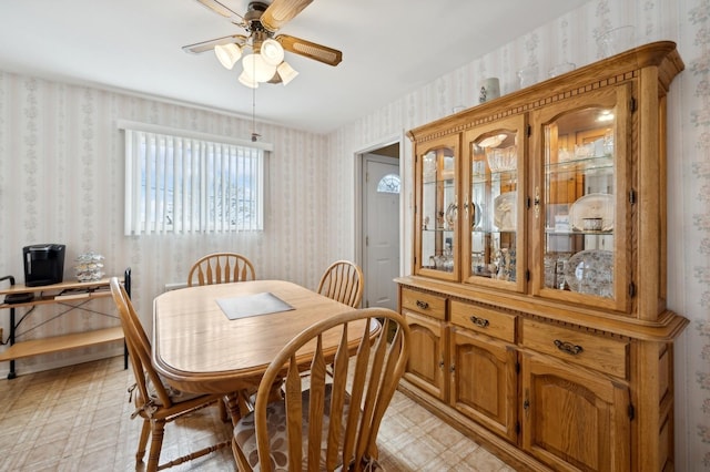 dining room with wallpapered walls, ceiling fan, and light floors