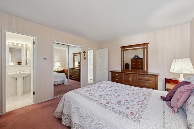 carpeted bedroom with wallpapered walls, ensuite bath, and a closet