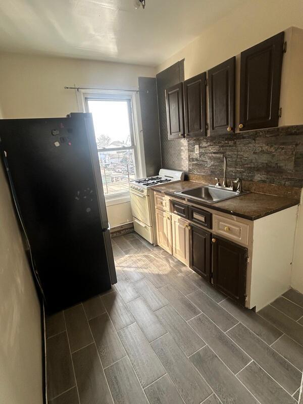 kitchen with decorative backsplash, dark countertops, freestanding refrigerator, gas range gas stove, and a sink