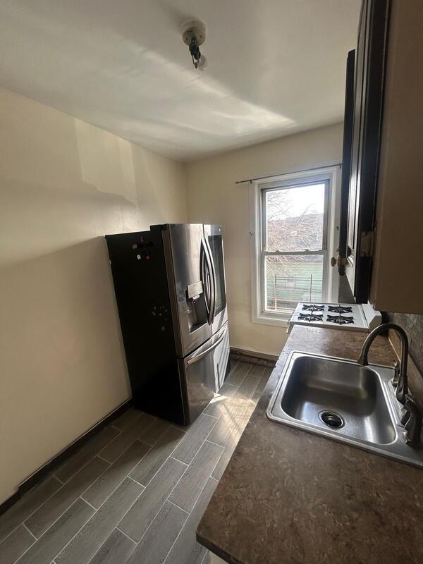 kitchen featuring dark countertops, a sink, stainless steel fridge with ice dispenser, and wood tiled floor