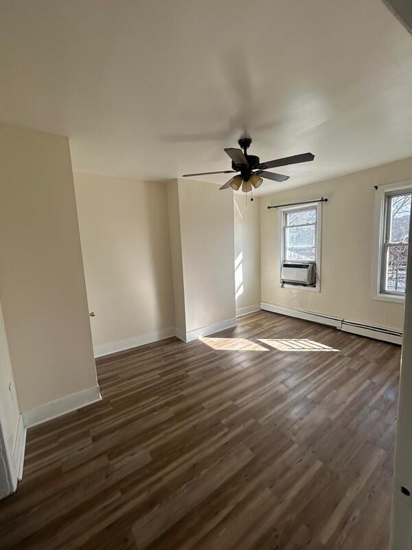 spare room featuring dark wood-style floors, a baseboard heating unit, cooling unit, and baseboards